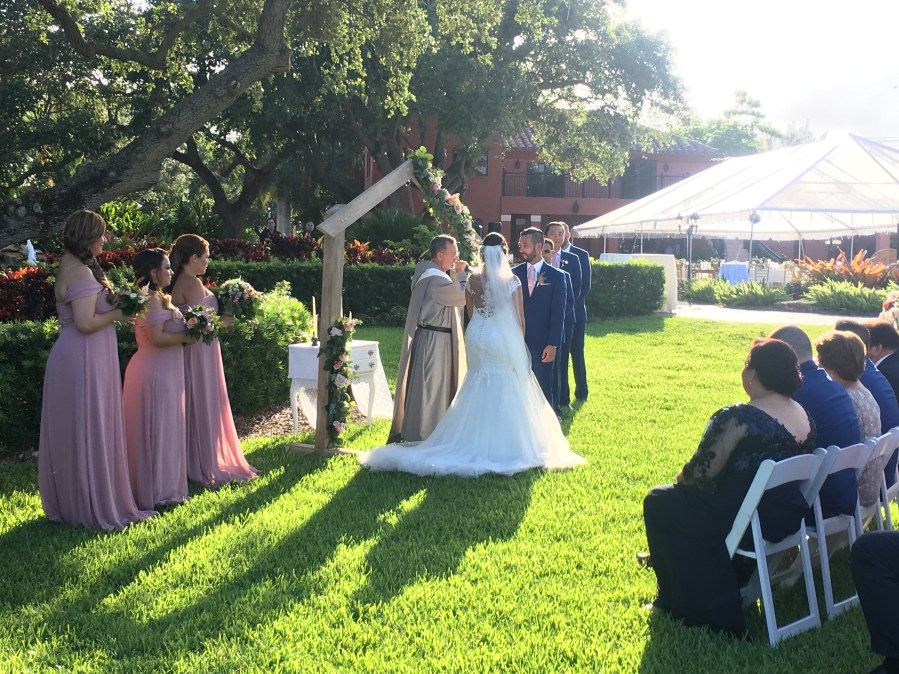 Outdoor wedding lawn ceremony under a wooden arch in South Florida