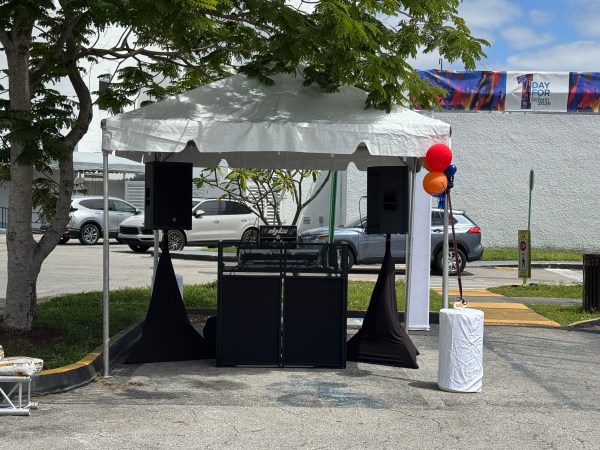 Outdoor DJ booth under a white canopy