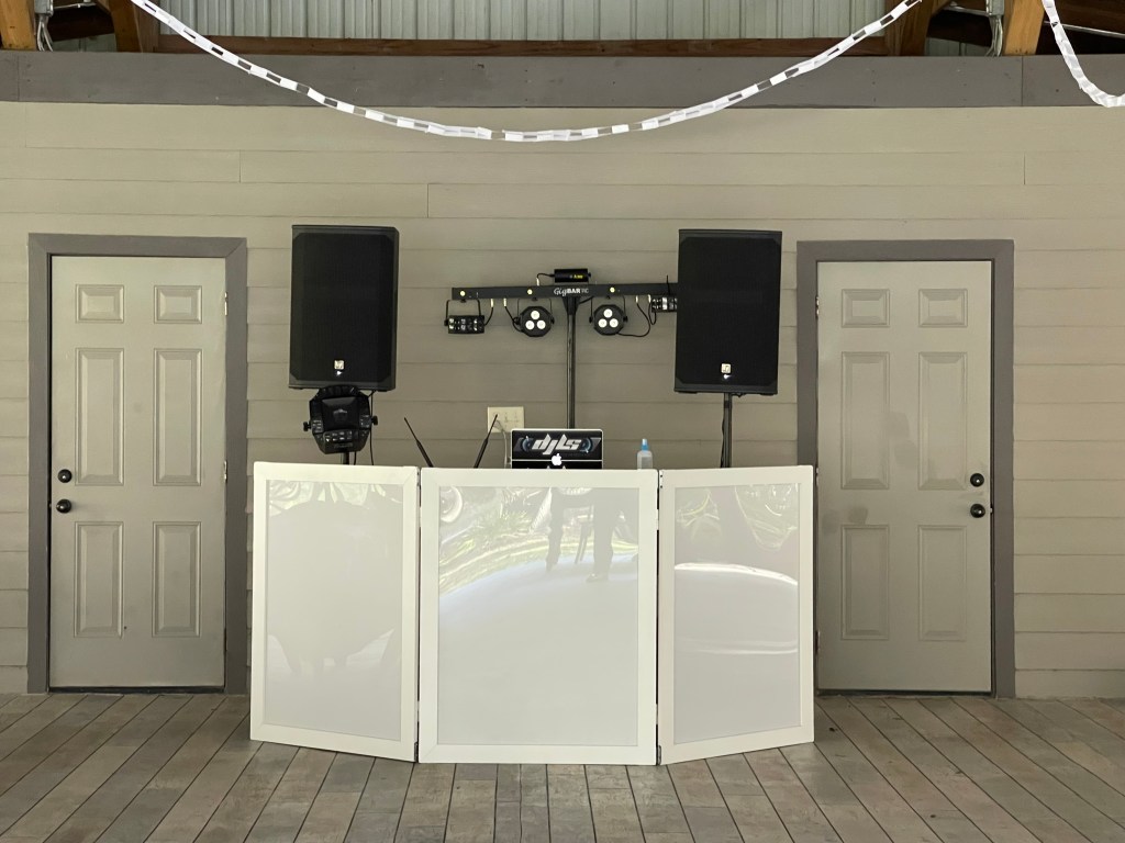 White DJ booth with paired speakers in an elegant event room