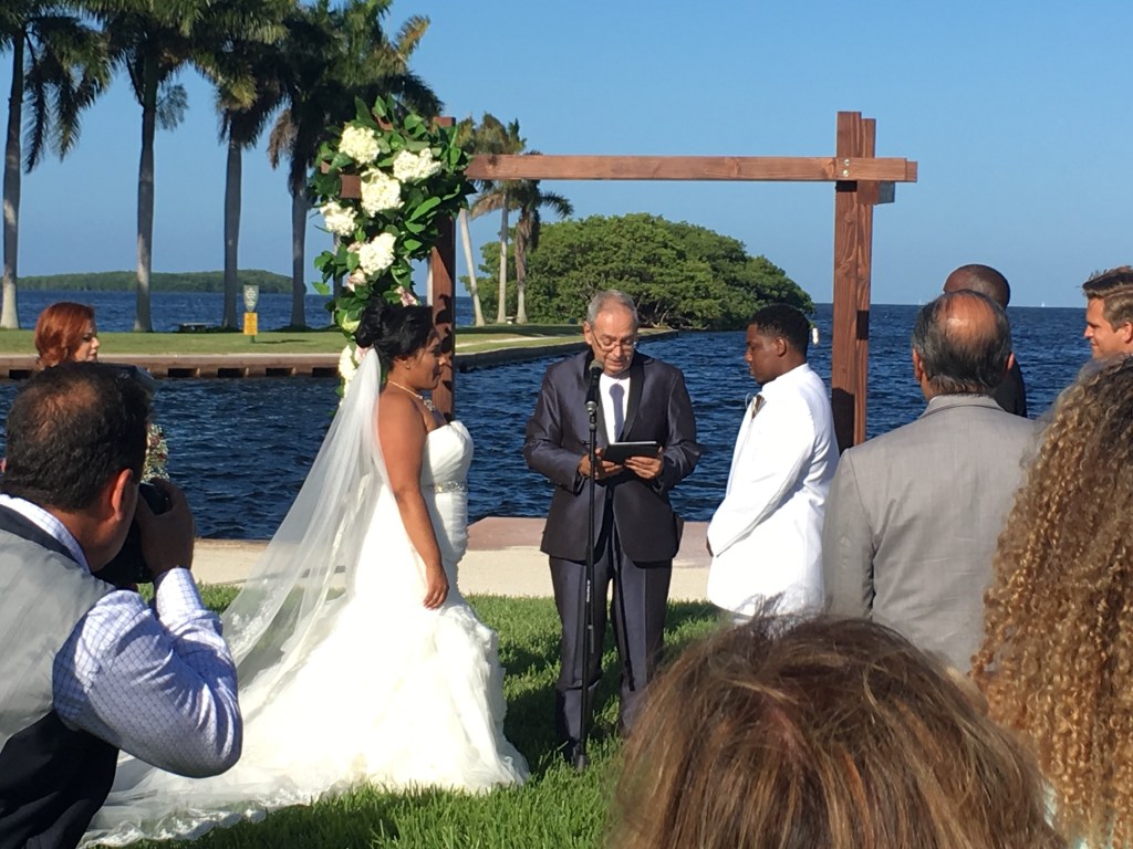 Waterfront wedding ceremony with microphone and officiant