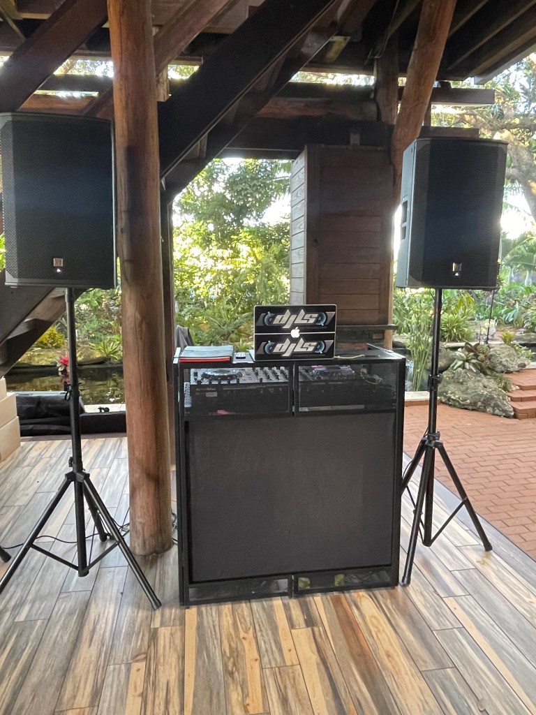 Ballroom DJ booth with speakers and warm wood event setup